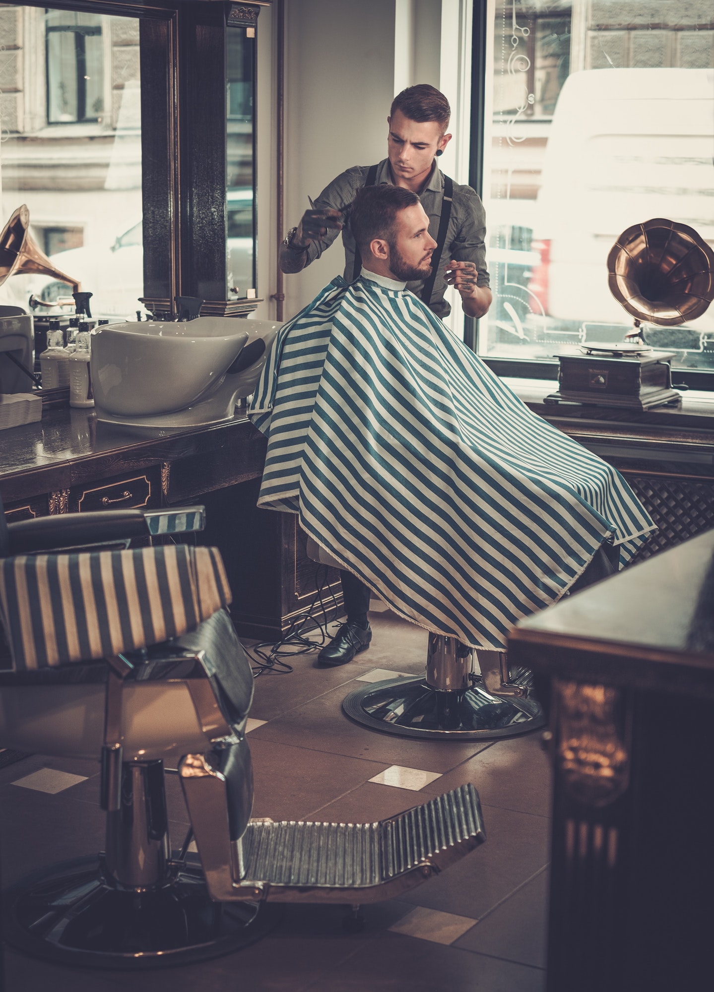 confident-man-visiting-hairstylist-in-barber-shop-.jpg